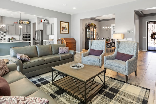 living area featuring plenty of natural light, baseboards, a notable chandelier, and recessed lighting