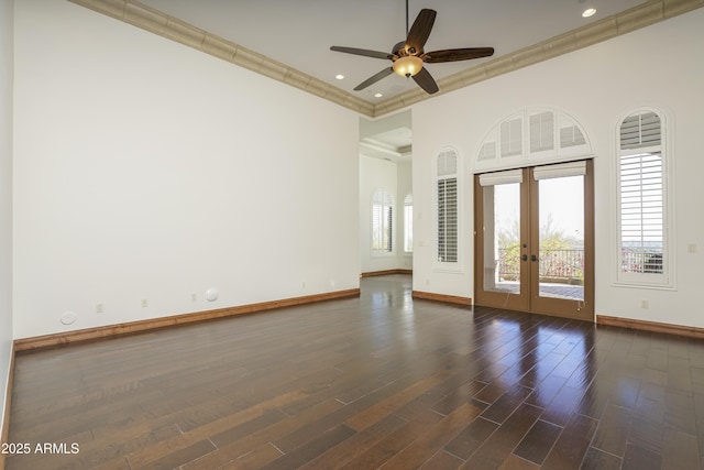 empty room featuring ceiling fan, dark hardwood / wood-style flooring, crown molding, and french doors