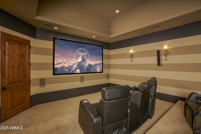 carpeted home theater room with a raised ceiling