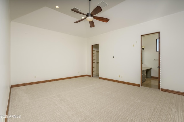 carpeted spare room featuring ceiling fan and vaulted ceiling