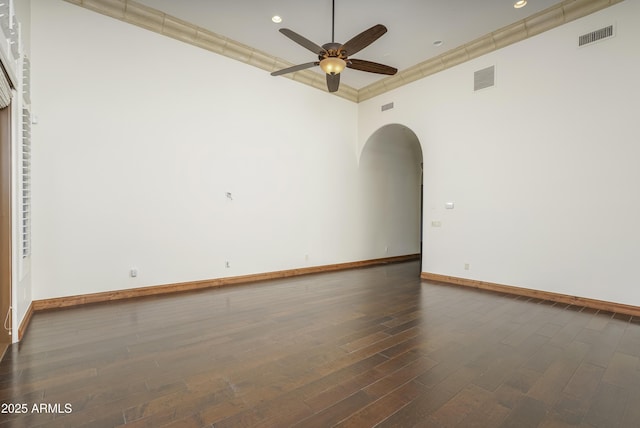 spare room with a towering ceiling, ceiling fan, and dark wood-type flooring