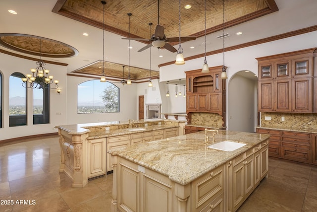 kitchen featuring backsplash, brick ceiling, crown molding, a spacious island, and sink