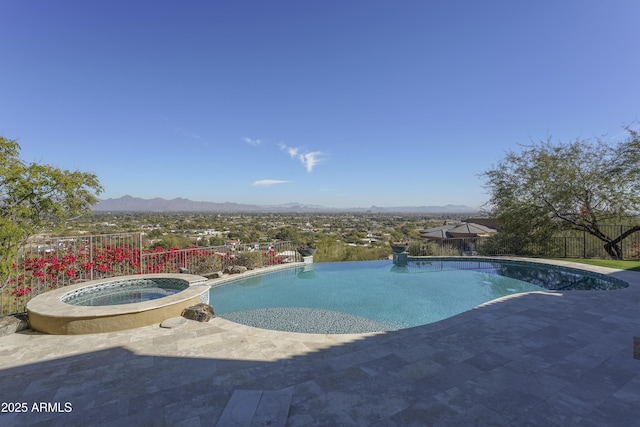 view of swimming pool featuring a mountain view, a patio, and an in ground hot tub