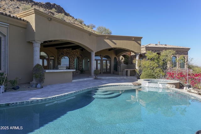 view of swimming pool featuring an in ground hot tub, a patio, an outdoor bar, and exterior kitchen