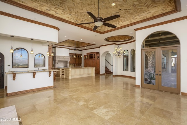 interior space with french doors, brick ceiling, crown molding, a center island, and hanging light fixtures