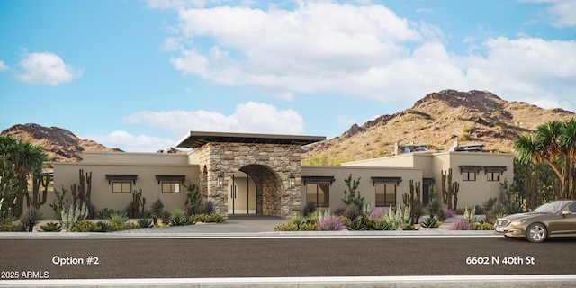 view of front of home featuring stone siding, a mountain view, and stucco siding