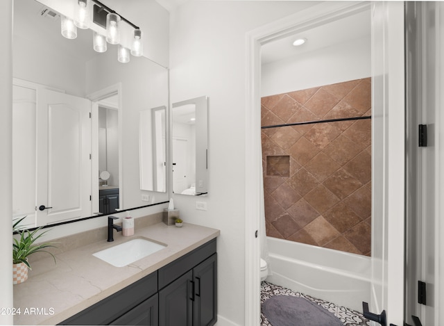 full bathroom with toilet, tiled shower / bath, and vanity