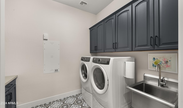 washroom with sink, washer and dryer, cabinets, and light tile patterned floors