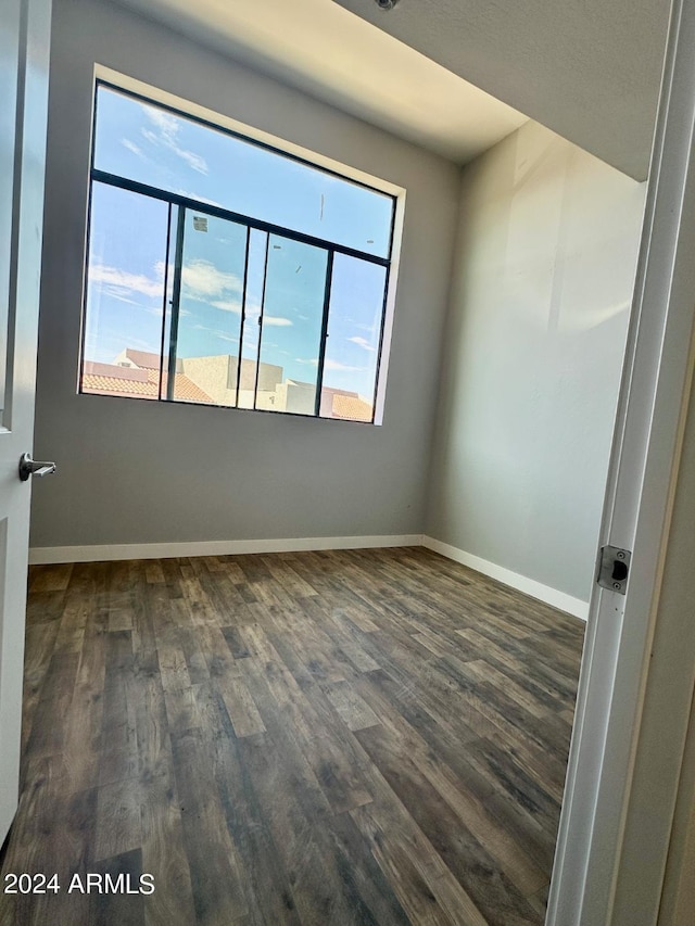 empty room with dark hardwood / wood-style flooring