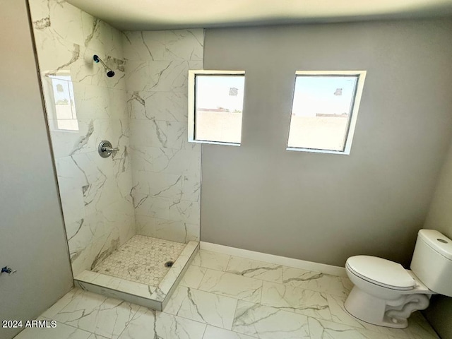 bathroom featuring tiled shower and toilet