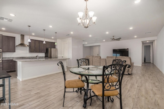 dining area with ceiling fan with notable chandelier and light wood-type flooring