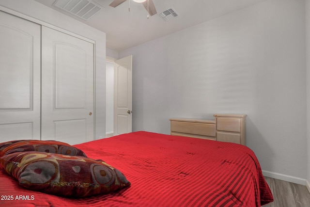 bedroom with ceiling fan, a closet, and wood-type flooring