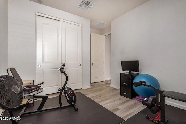 exercise room with light hardwood / wood-style floors