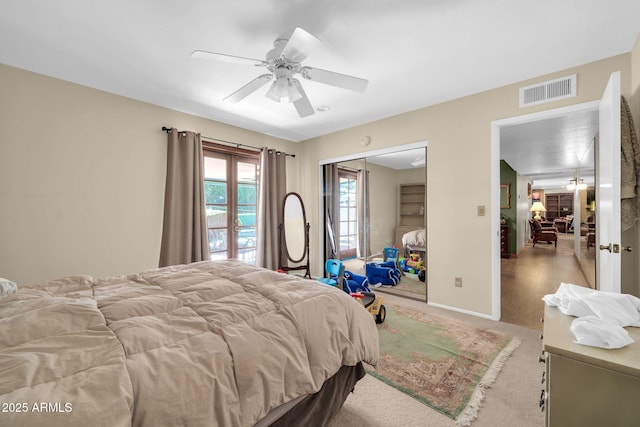 carpeted bedroom featuring ceiling fan, a closet, visible vents, and baseboards