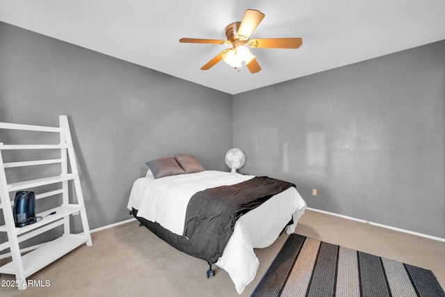 carpeted bedroom featuring baseboards and a ceiling fan