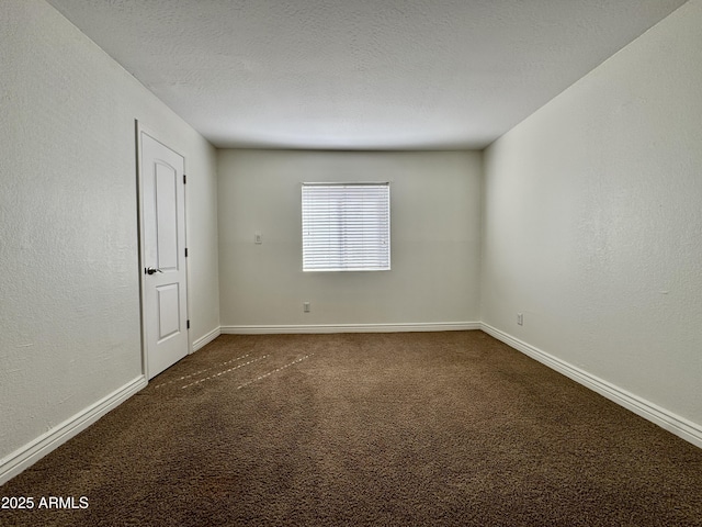 carpeted spare room with a textured wall, a textured ceiling, and baseboards