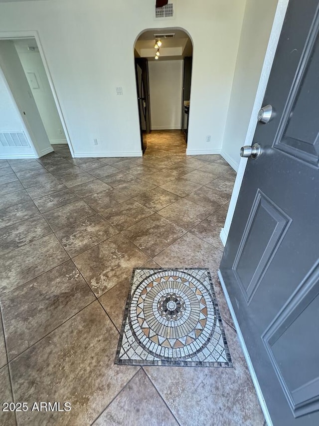 interior space with arched walkways, visible vents, and baseboards