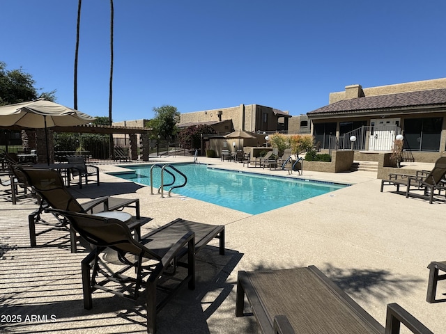 pool with a patio area and fence