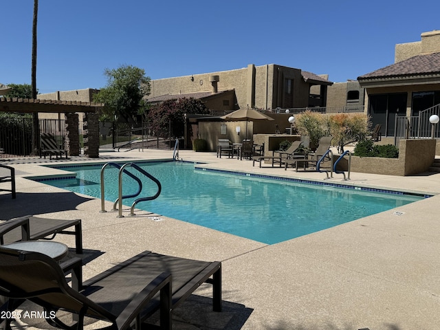 community pool with a patio area and fence