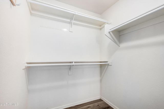 walk in closet with dark wood-type flooring