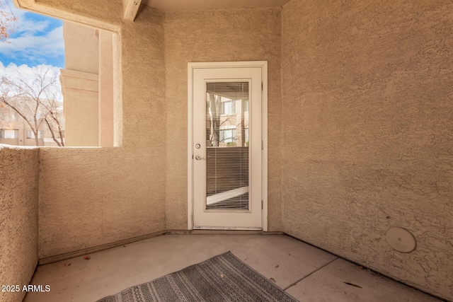 view of exterior entry featuring a balcony