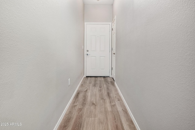 hallway with light hardwood / wood-style floors