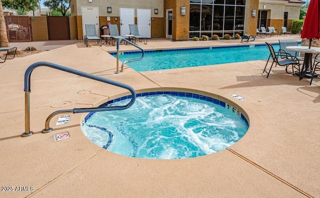 view of pool with a hot tub