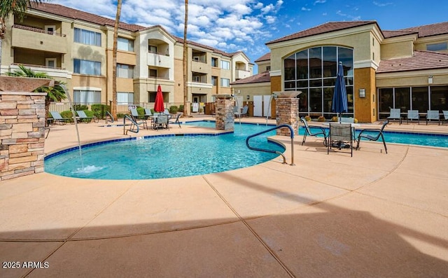 view of pool with a patio and pool water feature