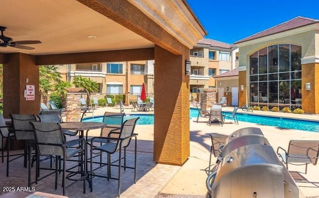 view of swimming pool featuring ceiling fan and a patio area