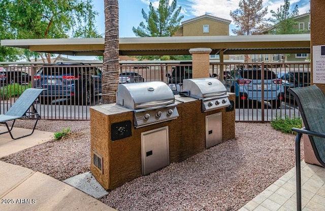 view of patio with exterior kitchen and a grill