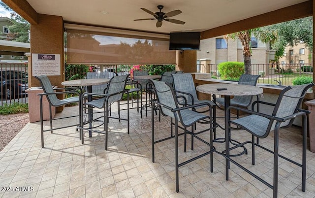 view of patio / terrace featuring ceiling fan and a bar