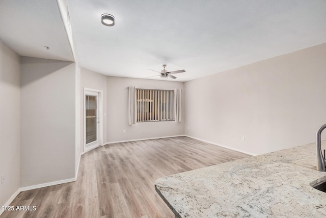 unfurnished living room featuring ceiling fan and light hardwood / wood-style floors