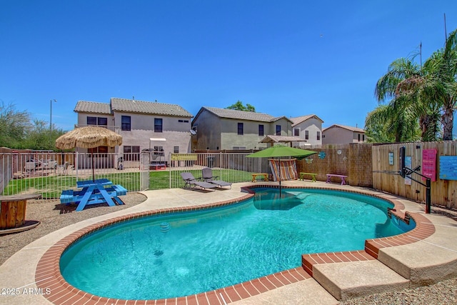 view of pool with fence, a patio, and a residential view