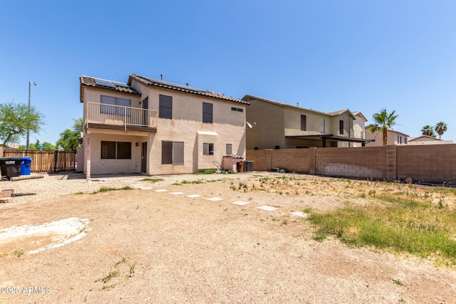 12825 W Virginia Ave, Avondale, AZ 85392 - rear view of property with solar panels, a balcony, stucco siding, a fenced backyard, and a tile roof