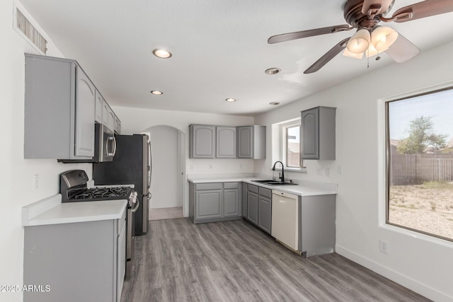 12825 W Virginia Ave, Avondale, AZ 85392 - kitchen with gray cabinets, stainless steel appliances, arched walkways, recessed lighting, and light wood-style flooring