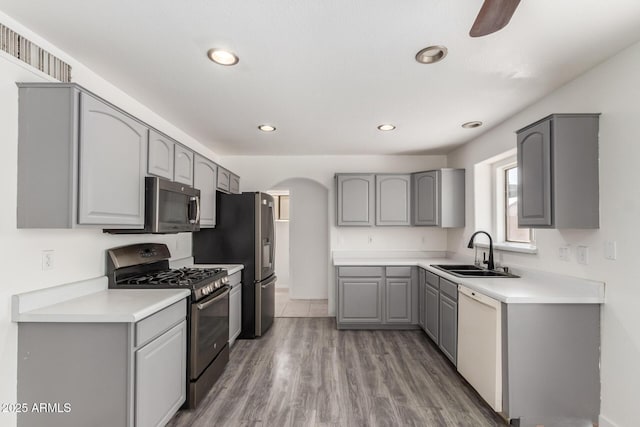 12825 W Virginia Ave, Avondale, AZ 85392 - kitchen featuring appliances with stainless steel finishes, gray cabinetry, arched walkways, light wood-type flooring, and recessed lighting