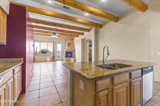 kitchen with sink, light tile patterned floors, dishwasher, ceiling fan, and a kitchen island with sink