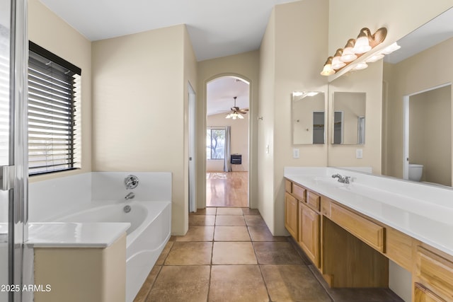 bathroom featuring a bathing tub, tile patterned flooring, vanity, ceiling fan, and toilet