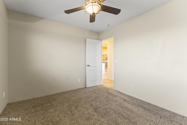 unfurnished room with light colored carpet and ceiling fan