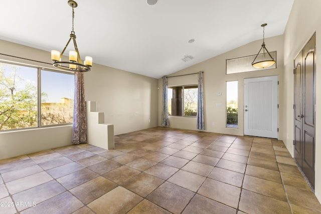 foyer with tile patterned flooring, a notable chandelier, and vaulted ceiling
