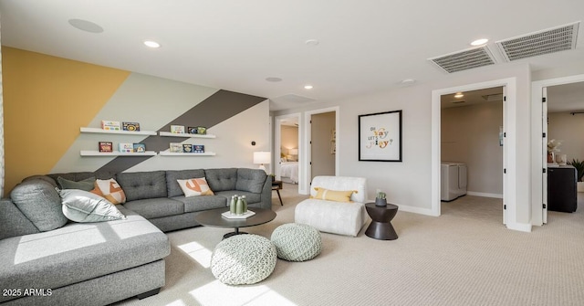 living room with light colored carpet and washer / clothes dryer