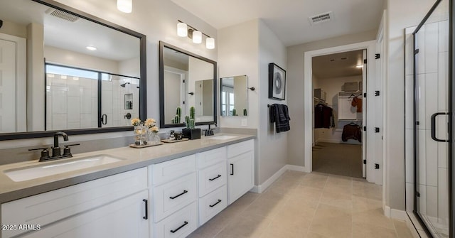 bathroom with a wealth of natural light, tile patterned flooring, an enclosed shower, and vanity