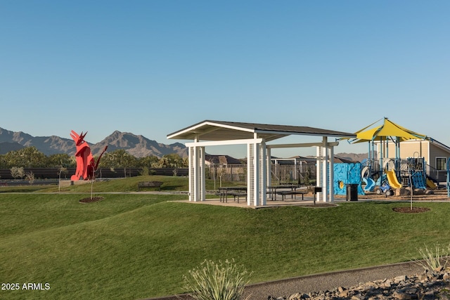 view of jungle gym featuring a mountain view and a yard