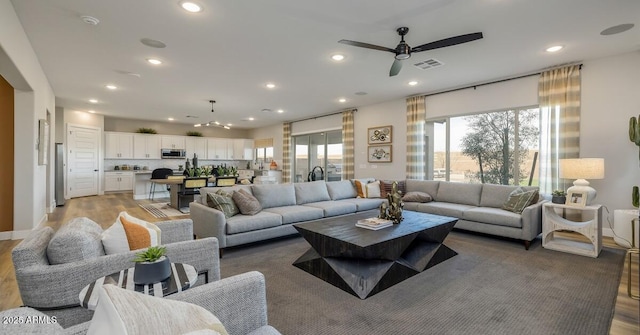 living room featuring ceiling fan and hardwood / wood-style floors