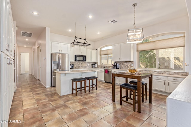 kitchen featuring a center island, white cabinets, stainless steel appliances, and sink