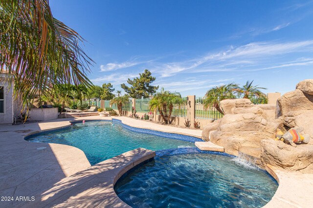 view of pool with a patio area and an in ground hot tub