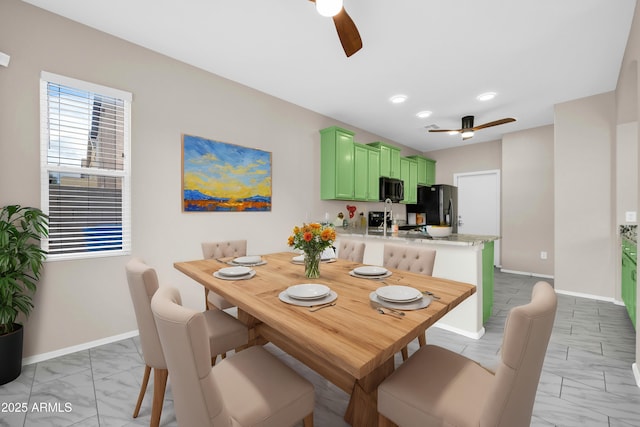 dining area featuring a ceiling fan, marble finish floor, and baseboards