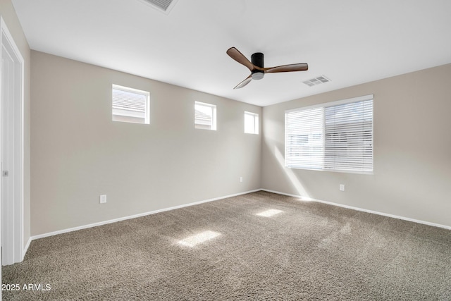 carpeted spare room featuring visible vents, baseboards, and a ceiling fan