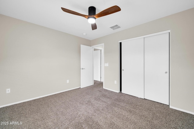 unfurnished bedroom with baseboards, visible vents, carpet floors, ceiling fan, and a closet