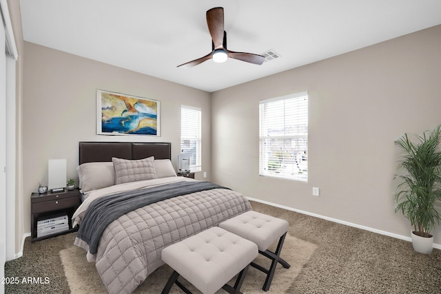 carpeted bedroom with visible vents, baseboards, and a ceiling fan